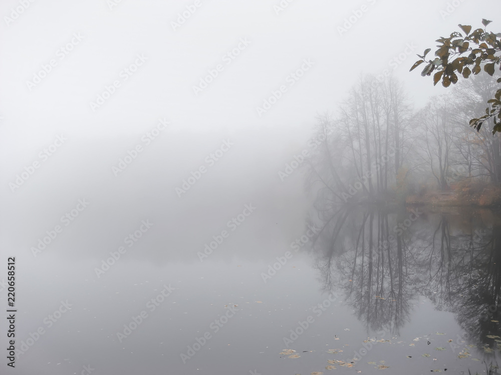 Thick dense fog, haze on the river during the late autumn. Misty, cloudy defocused lake. Landscape with morning fog Thick dense fog, haze on the river during the late autumn. Misty, cloudy defocused lake. Landscape with morning fog