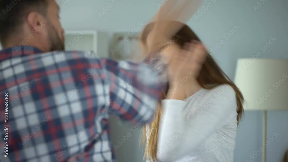 Aggressive man giving slap to his wife pleading him to calm down, violence