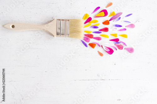 Paint brush and petal of flowers on white wooden background. Flat lay, top view