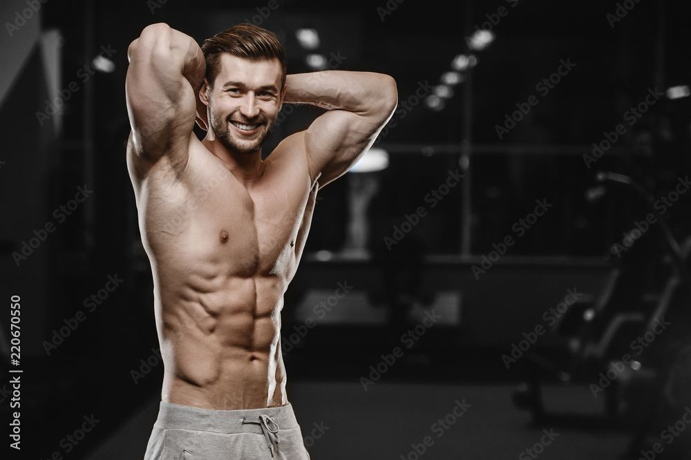Fototapeta premium sexy strong bodybuilder athletic men pumping up muscles with dumbbells