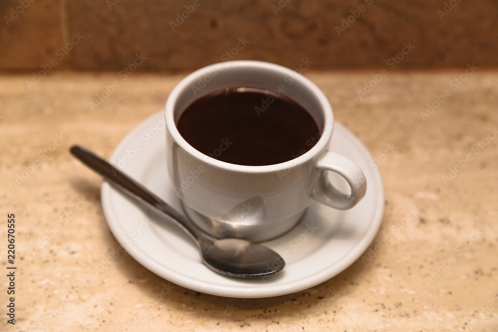 White cup of hot chocolate on wooden table White cup of hot chocolate on wooden table