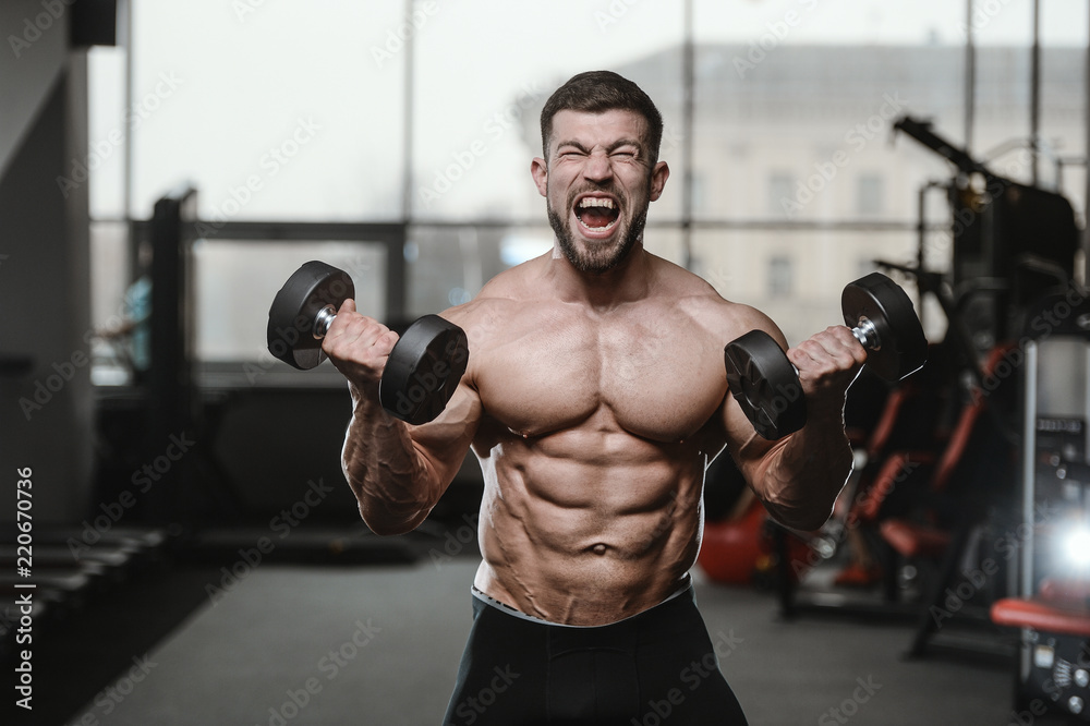 Brutal strong bodybuilder athletic men pumping up muscles with dumbbells Brutal strong bodybuilder athletic men pumping up muscles with dumbbells