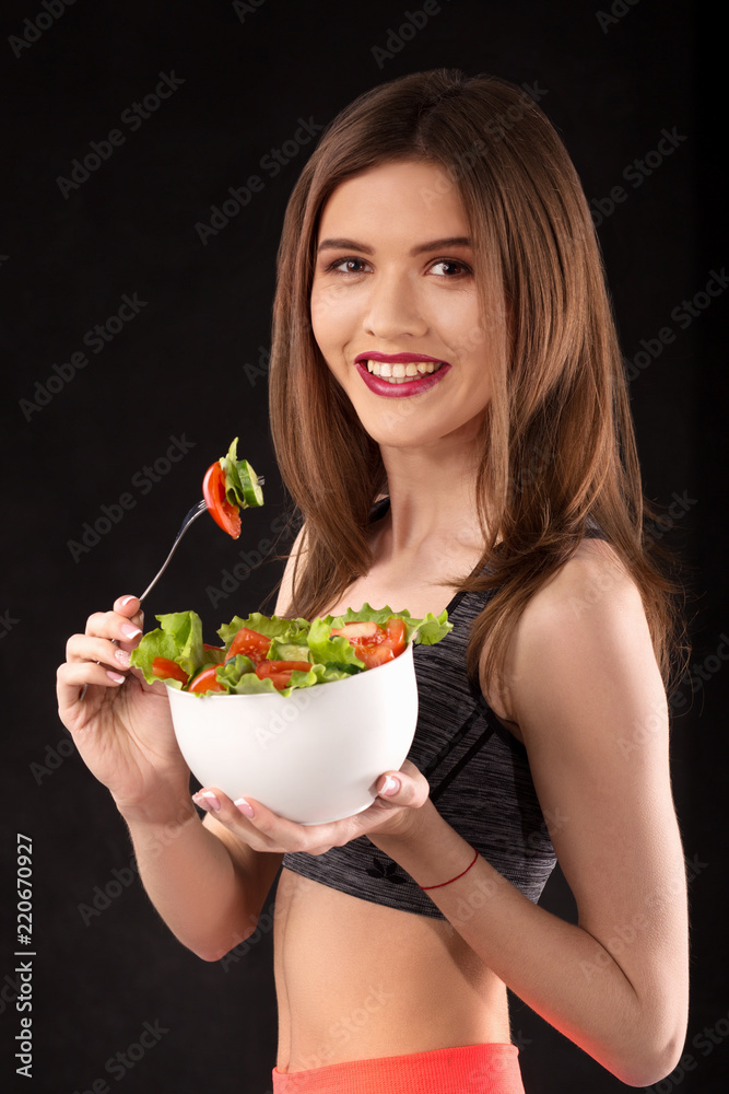 Young smilig athletic woman with salad and a fork Young smilig athletic woman with salad and a fork