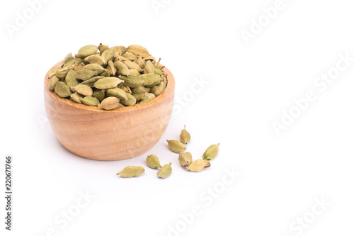 Green Cardamom in wooden bowl, cardamon or cardamum  isolated on white background (dried fruits of Elettaria cardamomum
