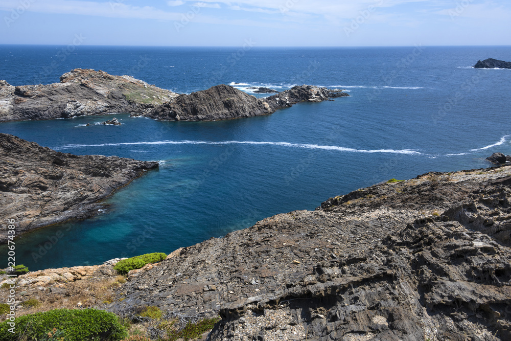 Spain, Catalonia, Cap de Creus: Panorama view of famous beautiful Spanish tourist destination with rocky cliff, laguna, blue sea water and cloudy sky in the background - concept nature. June 28, 2018 Spain, Catalonia, Cap de Creus: Panorama view of famous beautiful Spanish tourist destination with rocky cliff, laguna, blue sea water and cloudy sky in the background - concept nature. June 28, 2018