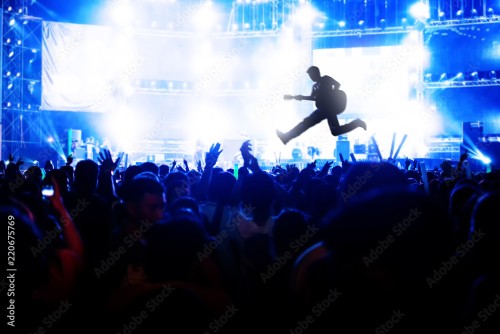 Blurred image of concert Crowd Cheering fans during live music with singer song on stage