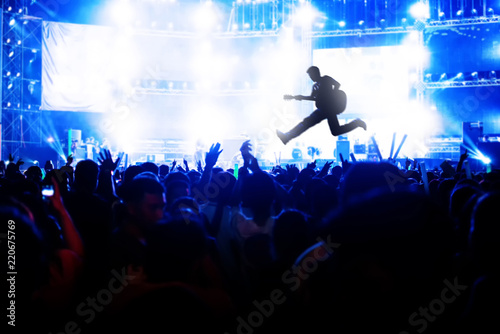 Blurred image of concert Crowd Cheering fans during live music with singer song on stage