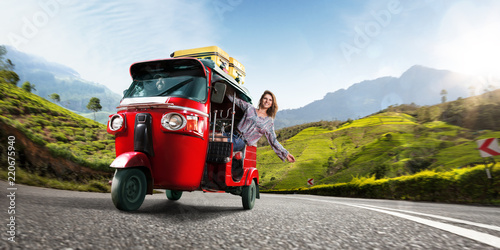 Happy woman travel by traditional srilankan transport, road near tea plantation in srilanka photo