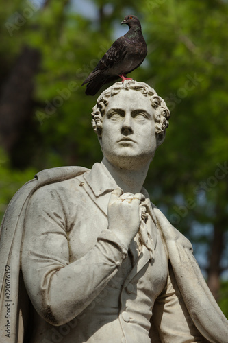 Close-up of the Statue of the English Writer Lord George Gordon Byron with a Pigeon sitting on the Head in the Park of Villa Borghese in Rome, Italy