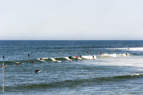 Surfers riding the waves in Malibu beach in summer time