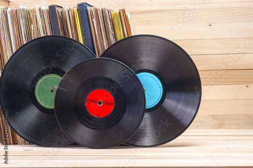 Vinyl record in front of a collection of albums, vintage process. Copy space for text