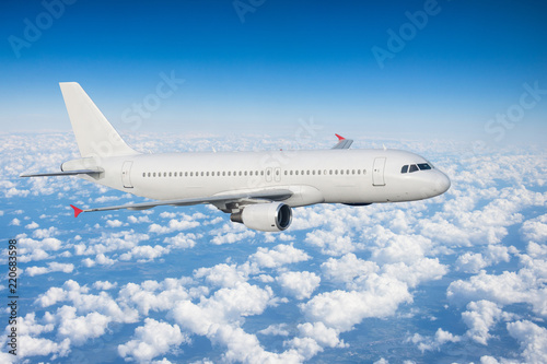 White airplane is climb flight heights, at the bottom there is a overcast clouds.