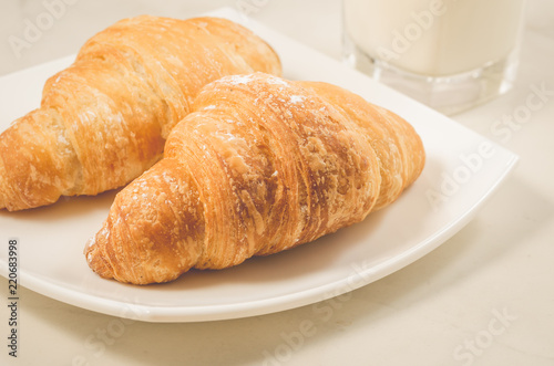 croissants in a white plate on a white table/croissants in a white square plate on a white table. Selective focus