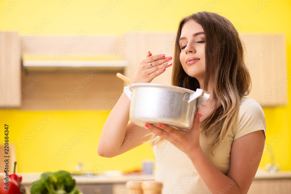 Young woman cooking soup in kitchen at home Young woman cooking soup in kitchen at home