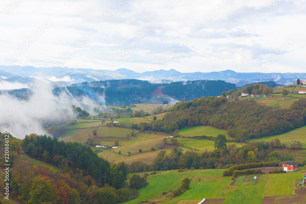 Green hills and mountains in the fog in Tineo, Asturias, Spain