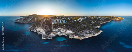 Arial drone view on Granadella beach sheltered between two rocky headlands in the province of Alicante, Valencia, Spain, Xabia, Javea, back side of the Montgo summer 2018. Golden hour sunset and pines photo