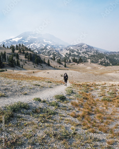 Hiker walking on the trail with mountains in the background