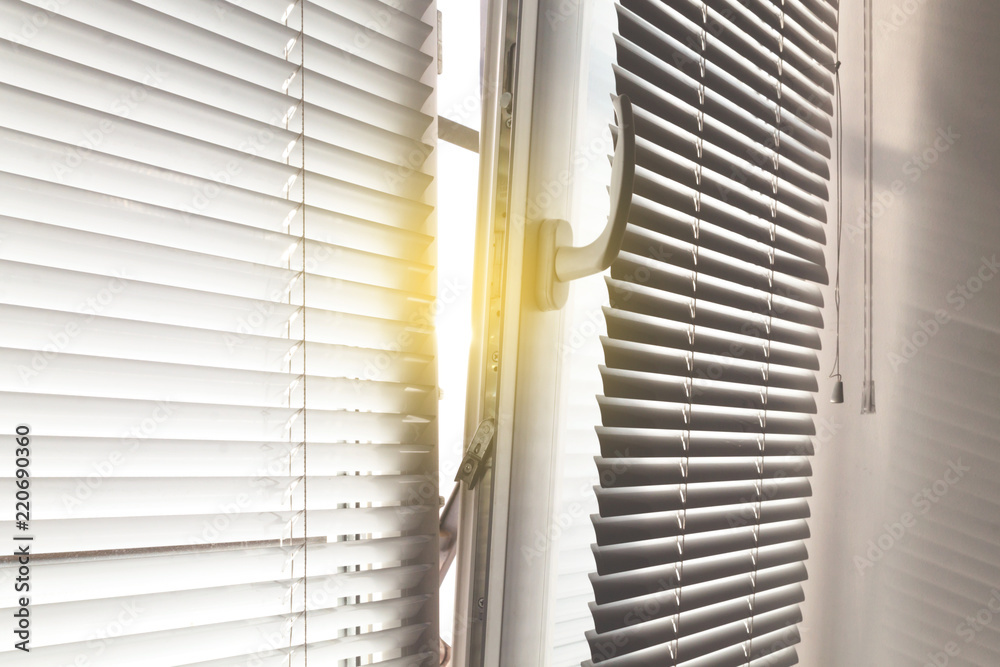 The background of the half open window with blinds sunlight