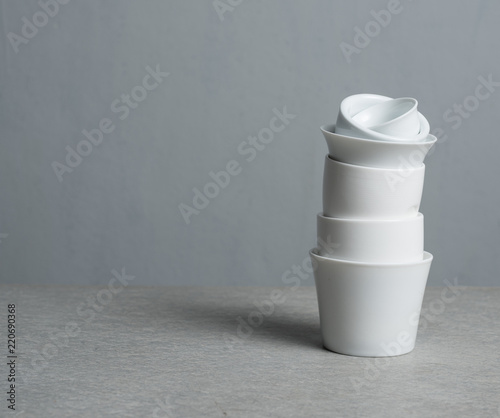 Stack of cups on table against gray background photo