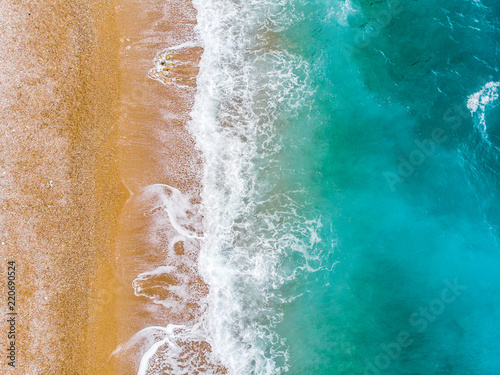 Top view aerial photo of an amazing sea waves with turquoise water from flying drone . Summer vacation holidays in Spain. Blue colours of the sea
