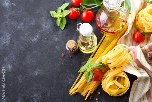 Cooking paste . Food ingredients for Italian spaghetti on black stone slate background with palm leave, copy space