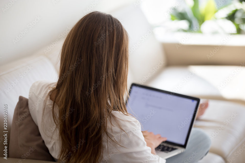 Woman using laptop for typing email at home, female blogger writer writing text for blog post, unemployed lady searching for work opportunities creating cover letter applying for new job, rear view Woman using laptop for typing email at home, female blogger writer writing text for blog post, unemployed lady searching for work opportunities creating cover letter applying for new job, rear view
