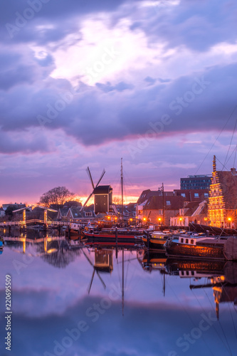 View of the canals of the city of Leiden with hoses, ships and boats at sunset. View of city channel with ships, the city of Leiden, Netherlands.