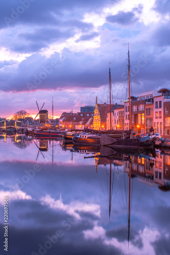 View of the canals of the city of Leiden with hoses  ships and boats at sunset. View of city channel with ships  the city of Leiden  Netherlands.