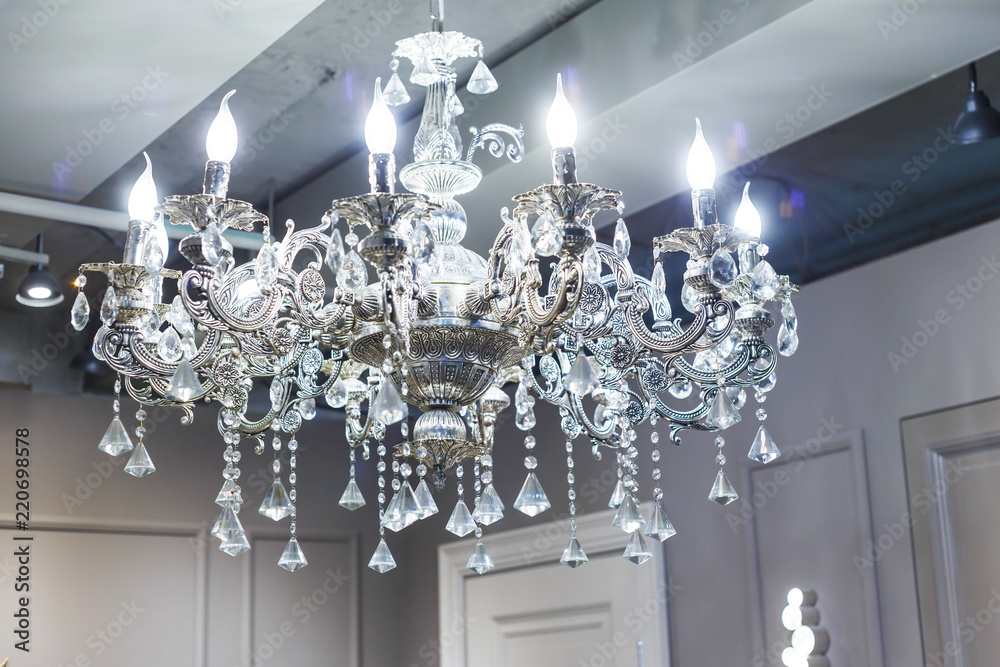 crystal chandelier shines hanging from the ceiling in the room