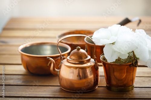 Copper old scratched vintage crockery kitchenware on the table