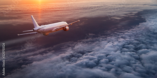 Samolot komercyjny lecący ponad dramatyczne chmury.