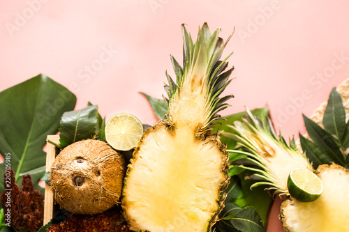 tropical fruits with leaves on a pink background
