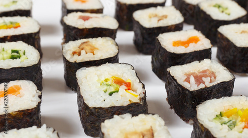 Assorted japanese sushi with salmon, tuna, eel and vegetables on a white background close up.