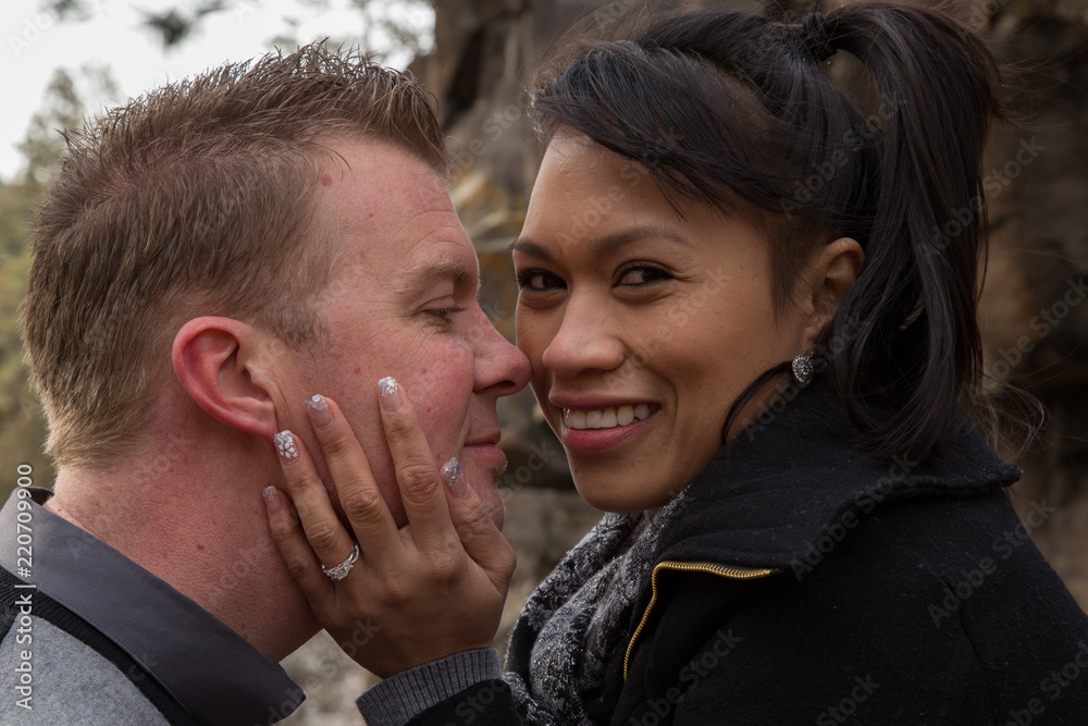 A newly engaged couple embracing and smiling at each other about to kiss A newly engaged couple embracing and smiling at each other about to kiss