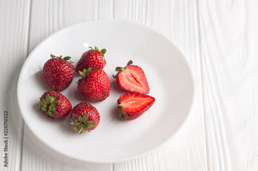 Fresh strawberries in a plate on a white wooden background. Fresh strawberries in a plate on a white wooden background.