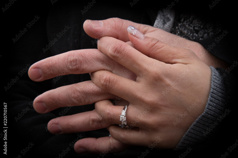 Interlocking fingers holding hands with an Engagement ring Interlocking fingers holding hands with an Engagement ring