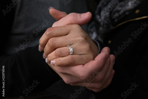 Beautiful couple holding hands showing wedding ring