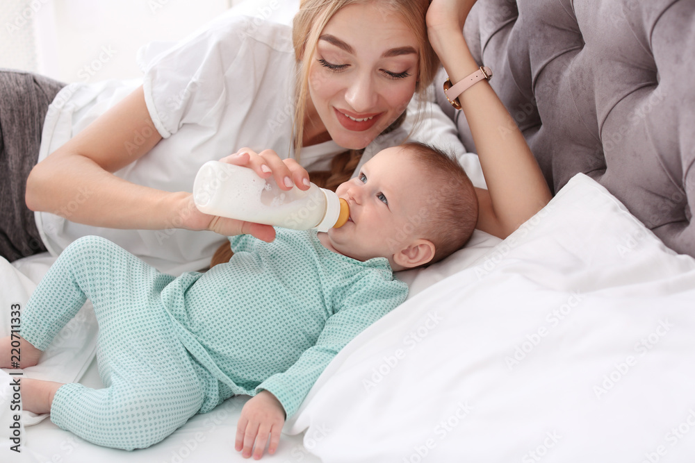 Woman feeding her child in bedroom. Healthy baby food Woman feeding her child in bedroom. Healthy baby food