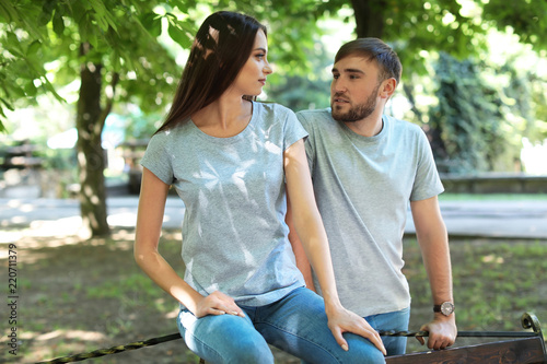 Young couple wearing gray t-shirts in park