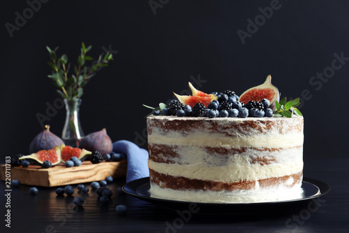 Delicious homemade cake with fresh berries served on dark wooden table