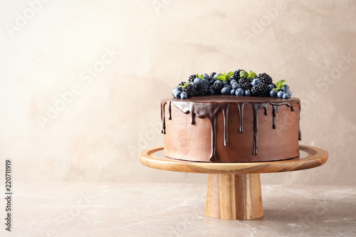 Fresh delicious homemade chocolate cake with berries on table against color background. Space for text