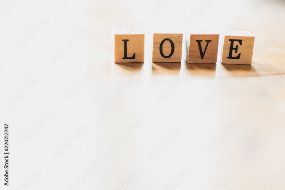 Obraz premium Word love on wooden dice and white background.
