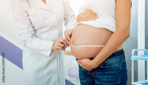 A gynecologist examines a pregnant woman. Patient at doctor office. Pregnant woman at hospital.