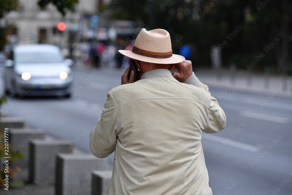 A stylish dressed old man is phoning in Berlin Germany A stylish dressed old man is phoning in Berlin Germany