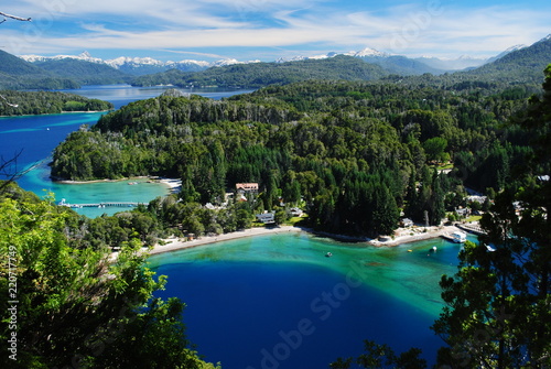 Beautiful incredible view of a blue, green and turquoise bay of a lake, surrounded by a forest and with the Andes in the horizon, Villa la Angostura, Argentina
