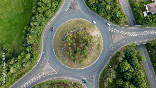 Top down aerial view of a traffic roundabout on a main road in an urban area of the UK