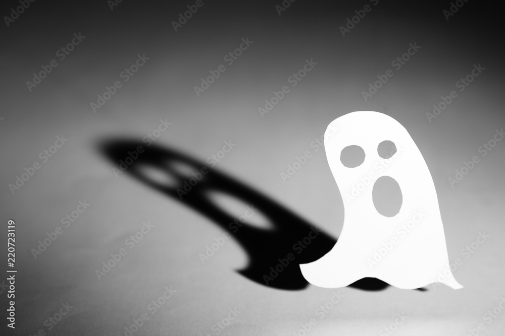 Halloween background concept. Cut out paper ghost and graphic shadow, funny  face on white background. Stock Photo | Adobe Stock