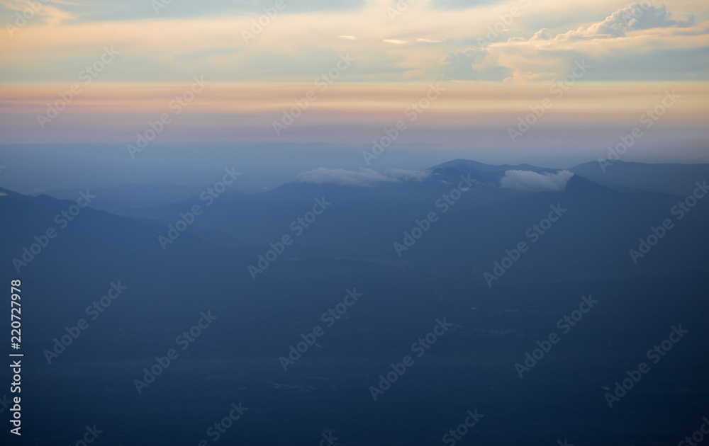 Background, high angle from the passenger plane. You can see the scenery by the distance (mountains, rivers, sky, fog, houses), the photos may be blurred during the flight.