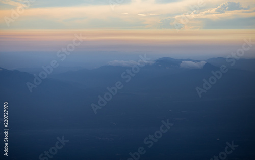 Background, high angle from the passenger plane. You can see the scenery by the distance (mountains, rivers, sky, fog, houses), the photos may be blurred during the flight. © bangprik
