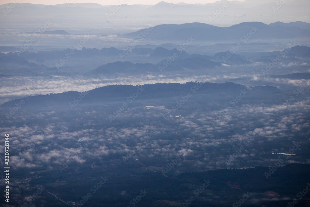 Background, high angle from the passenger plane. You can see the scenery by the distance (mountains, rivers, sky, fog, houses), the photos may be blurred during the flight.